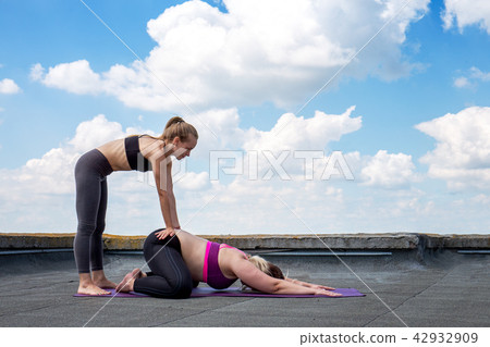a yoga teacher helps perform asana a yoga teacher helps perform asana 42932909