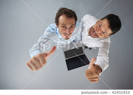 Two man with laptop showing thumb up Two man with laptop showing thumb up 42932910
