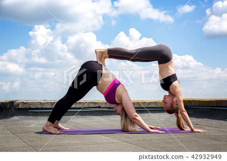 Two girls are engaged in acro yoga Two girls are engaged in acro yoga 42932949
