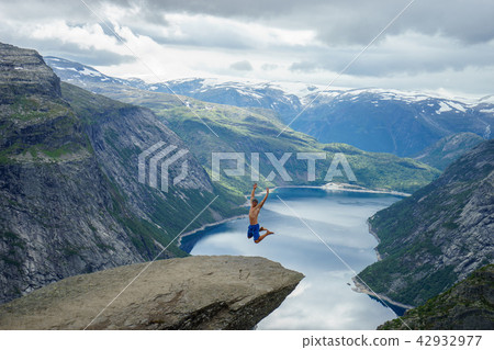 Young man jump on the edge Trolltunga. Norway Young man jump on the edge Trolltunga. Norway 42932977