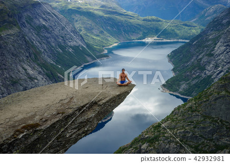 Yog is praying on the edge Trolltunga. Norway 42932981