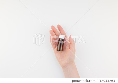 Woman hand with small glass bottle isolated Woman hand with small glass bottle isolated 42933263