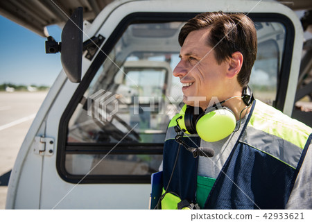 Smiling airport worker with truck cab on background Smiling airport worker with truck cab on background 42933621
