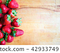 Strawberries on a wooden board with empty space 42933749