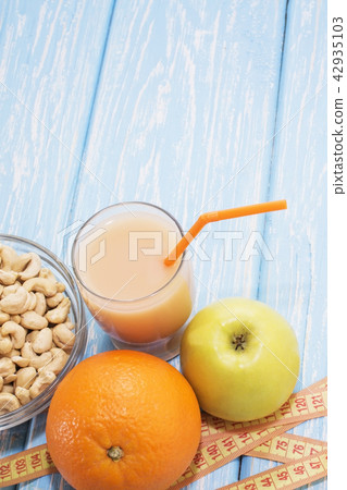 healthy breakfast. The cashew nuts in a white bowl. Green Apple, orange, banana. Flat top view 42935103