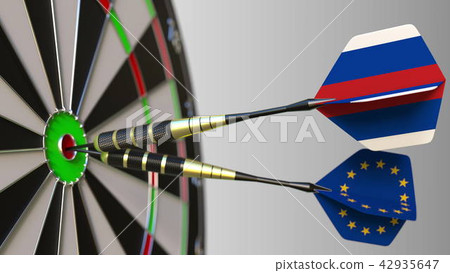 Flags of Russia and the European Union on darts hitting bullseye of the target. International 42935647