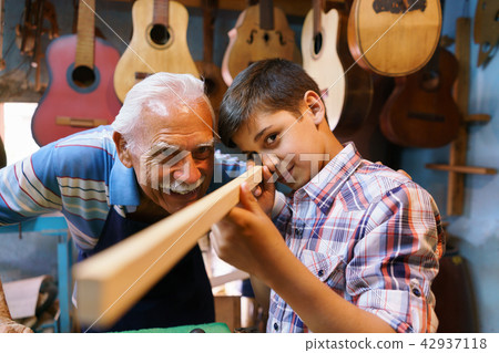 Old Man Luter Teaching Grandson Boy Chiseling Wood Old Man Luter Teaching Grandson Boy Chiseling Wood 42937118