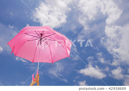 two hand are holding a umbrella on blue sky two hand are holding a umbrella on blue sky 42938689