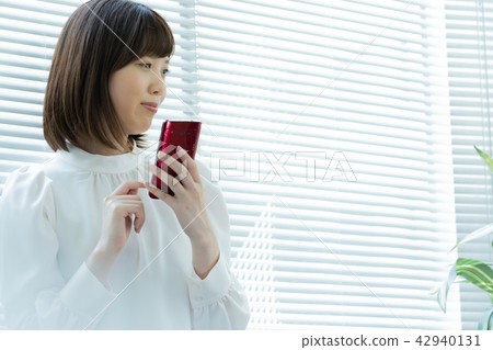 A woman standing by the window A woman standing by the window 42940131