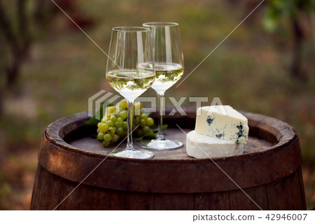 Wine glasses on wooden barrel with grapes Wine glasses on wooden barrel with grapes 42946007