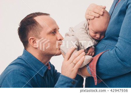 a man kisses a newborn child, who lies in the hand a man kisses a newborn child, who lies in the hand 42947936