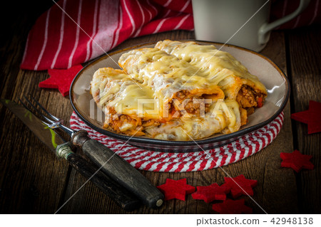 Italian lasagna rolls on a plate. 42948138