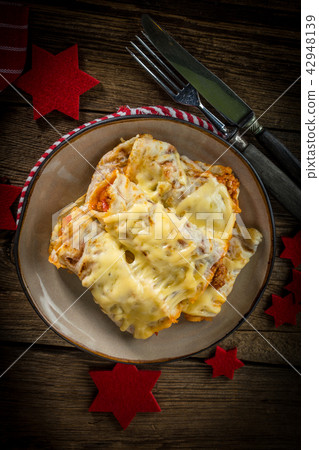 Italian lasagna rolls on a plate. 42948139