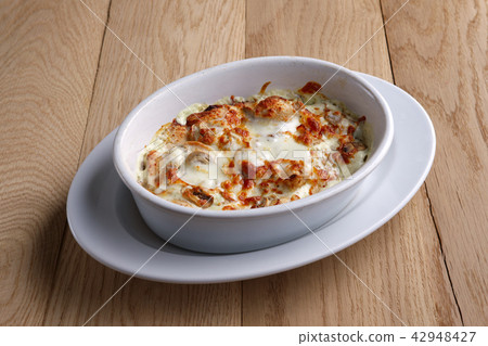 Fried ham, bacon covered with melted cheese Fried ham, bacon covered with melted cheese 42948427