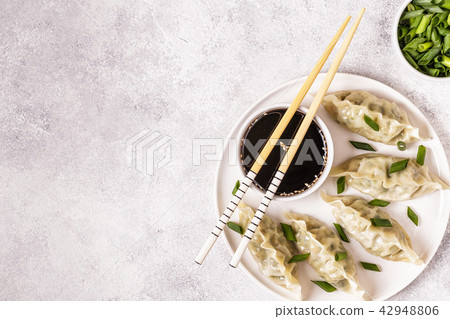 Asian dumplings, soy sauce, chopsticks, top view Asian dumplings, soy sauce, chopsticks, top view 42948806