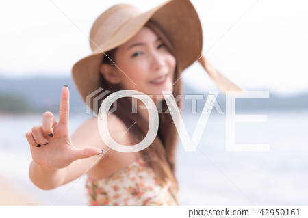 Young woman showing love sign by L symbol Young woman showing love sign by L symbol 42950161