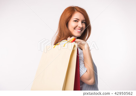 People, sale and consumerism concept - Attractive woman with red hair over white background holding People, sale and consumerism concept - Attractive woman with red hair over white background holding 42950562