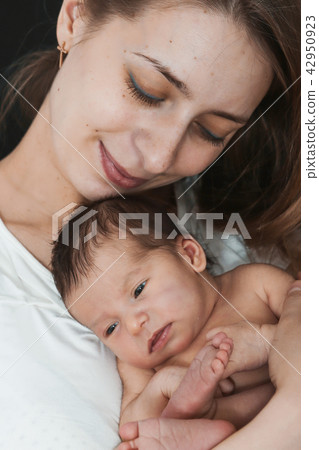 newborn baby lying on the hands of parents 42950923