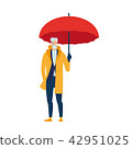 An elderly man in a yellow cloak with an umbrella. 42951025