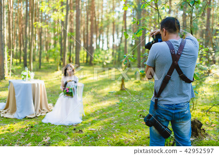 Photographer taking Pictures of the Bride in the forest Photographer taking Pictures of the Bride in the forest 42952597