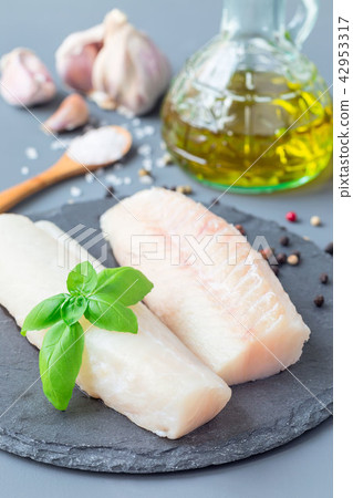Raw cod fillet with spices, pepper, salt, basil 42953317
