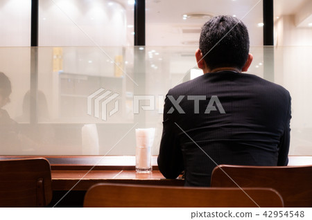 A back view of a salaried worker who takes a break at a coffee shop A back view of a salaried worker who takes a break at a coffee shop 42954548