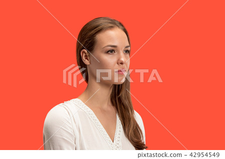 The serious business woman standing and looking at camera against red background. 42954549