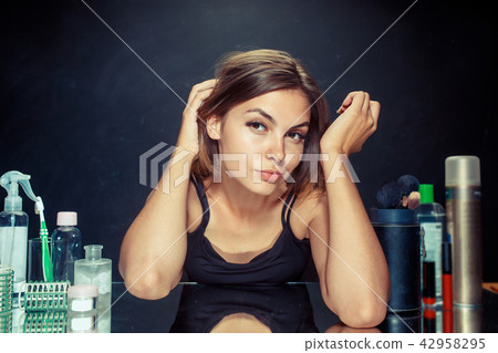 Beauty woman after applying makeup. Beautiful girl looking in the mirror and applying cosmetic with Beauty woman after applying makeup. Beautiful girl looking in the mirror and applying cosmetic with 42958295