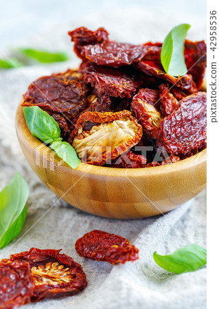 Organic sun-dried tomatoes in a wooden bowl. Organic sun-dried tomatoes in a wooden bowl. 42958536