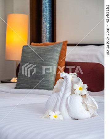 White elephant towel and comfortable pillow on bed 42963163