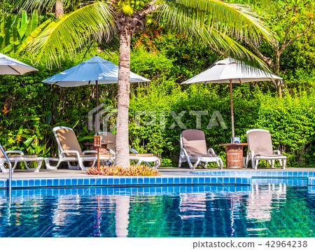 Umbrella and chair around luxury outdoor swimming pool Umbrella and chair around luxury outdoor swimming pool 42964238