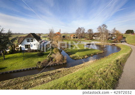 Dutch polder landscape with a farm and some houses Dutch polder landscape with a farm and some houses 42972032