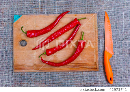 Red bitter, hot peppers lying on wooden board Red bitter, hot peppers lying on wooden board 42973741