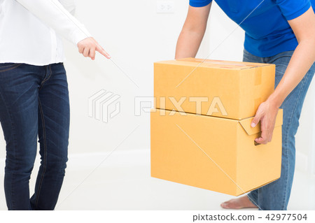 Woman receiving package from delivery man Woman receiving package from delivery man 42977504