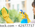housekeeper cleaning the mirror with green cloth. 42977737