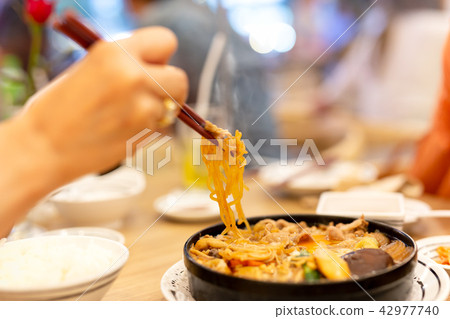 Hand with chopsticks eating Japanese udon noodles. Hand with chopsticks eating Japanese udon noodles. 42977740