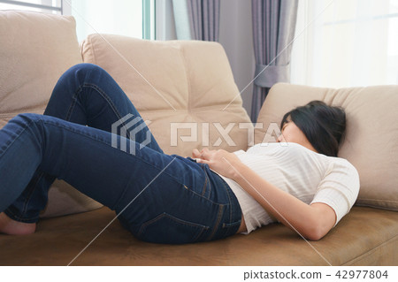 Woman touching her own belly with stomachache Woman touching her own belly with stomachache 42977804