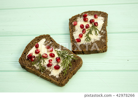 Sandwiches with butter and berries pomegranate  42978266