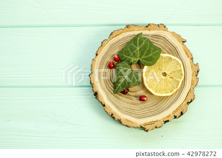 Cut wood with slices of lemon and pomegranate  42978272