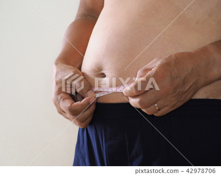 A fat man measuring the waist A fat man measuring the waist 42978706