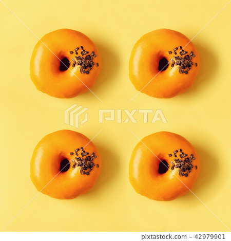Square crop of sweet doughnut with orange icing on 42979901