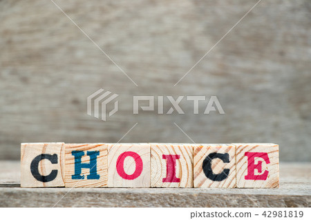 Letter block in word choice on wood background 42981819