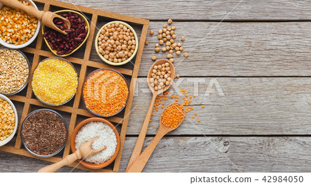Cereals and legumes assortment on wooden table 42984050