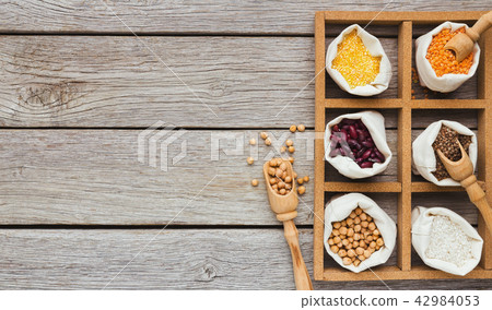 Cereals and legumes assortment on wooden table 42984053