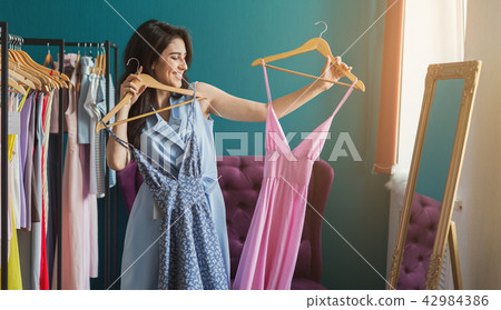 Two young gwomen shopping. Girls choose clothes at store 42984386