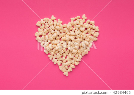 Heart made cereals on a pink background Heart made cereals on a pink background 42984465