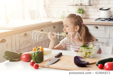 Little girl eating fresh salad Little girl eating fresh salad 42984871