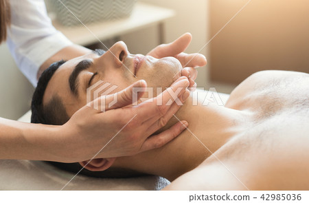Handsome man getting professional face treatment Handsome man getting professional face treatment 42985036