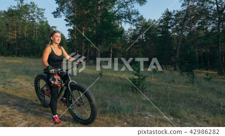 Fat bike also called fatbike or fat-tire bike in summer riding in the forest. Fat bike also called fatbike or fat-tire bike in summer riding in the forest. 42986282