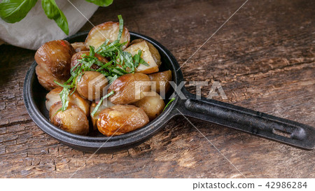 Baked potatoes in a frying pan with basi 42986284
